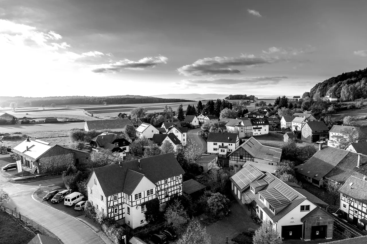 Vue aérienne d'un village de campagne dont plusieurs toits portent des panneaux solaires